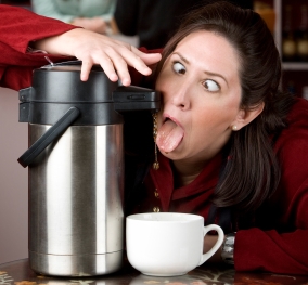Woman drinking coffee directly from a dispenser